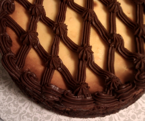 Ganache latticework atop the white chocolate layer. A bit of the chocolate crust is visible along the side.