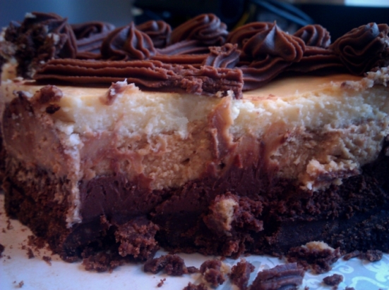The layers: chocolate crust; chocolate layer; peanut butter layer; white chocolate topping; and ganache latticework on top. This cheesecake was demolished before I was able to get a proper picture of the layers or of a nice, neat slice.